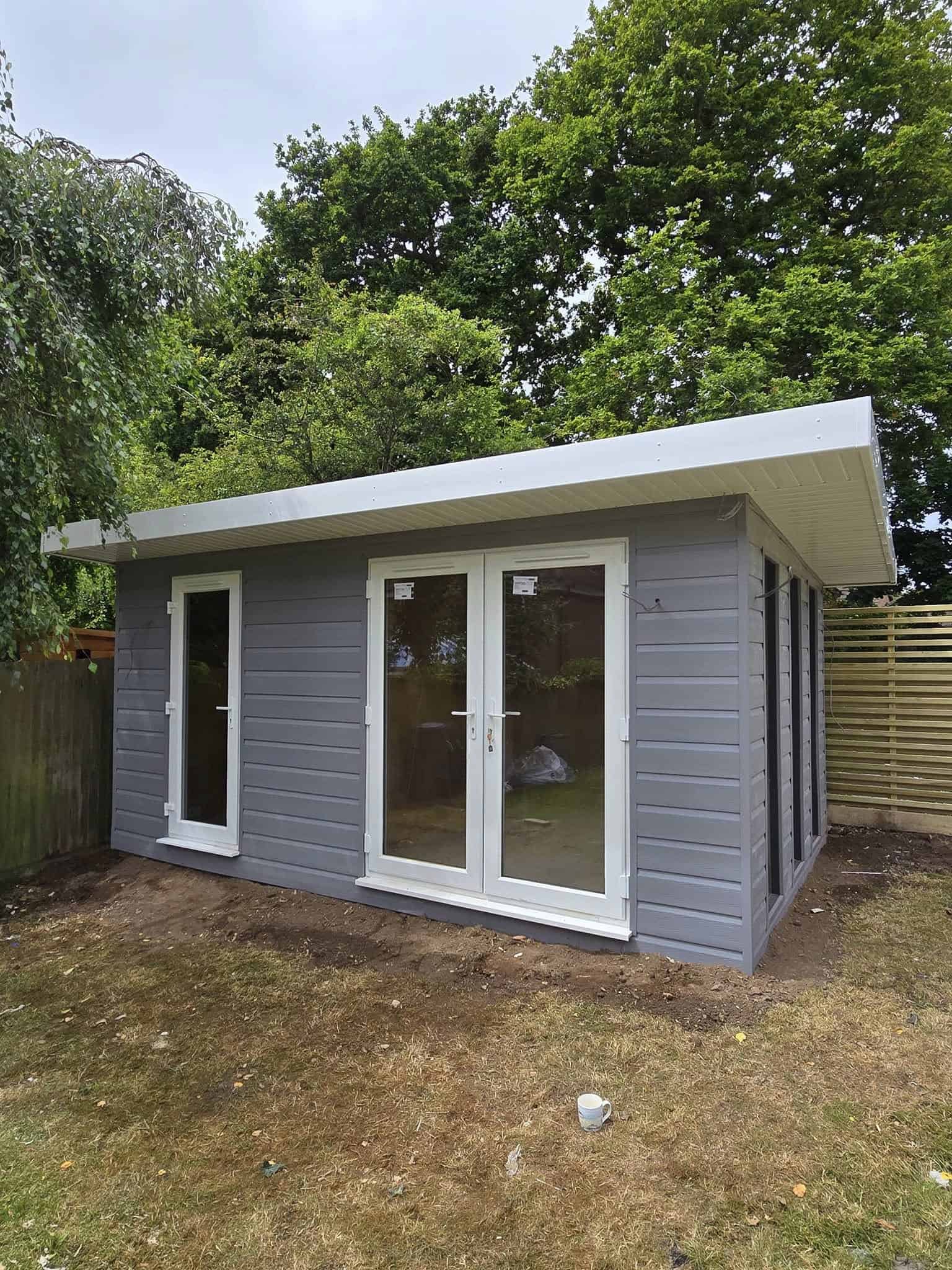 Storm grey Fortex-style cladding garden room, same design shown lit up at night